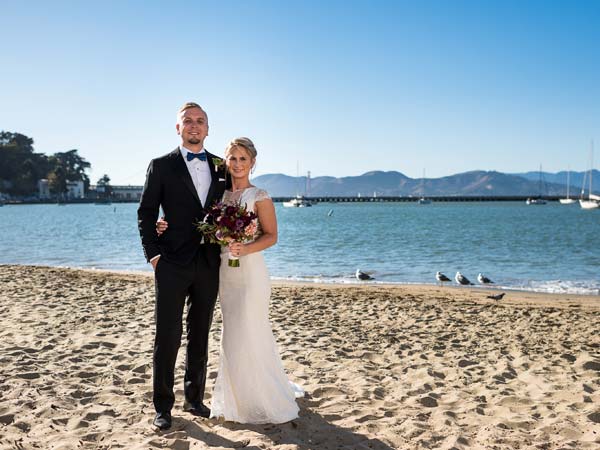 A bride and groom on the beach in San Francisco.