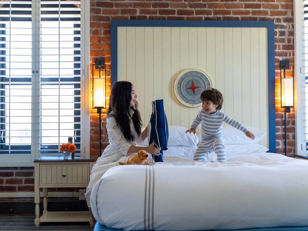 Mom And Son Playing On Guestroom Bed