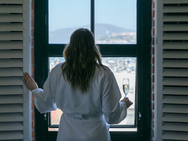 Lady Looking Out A Guestroom Window